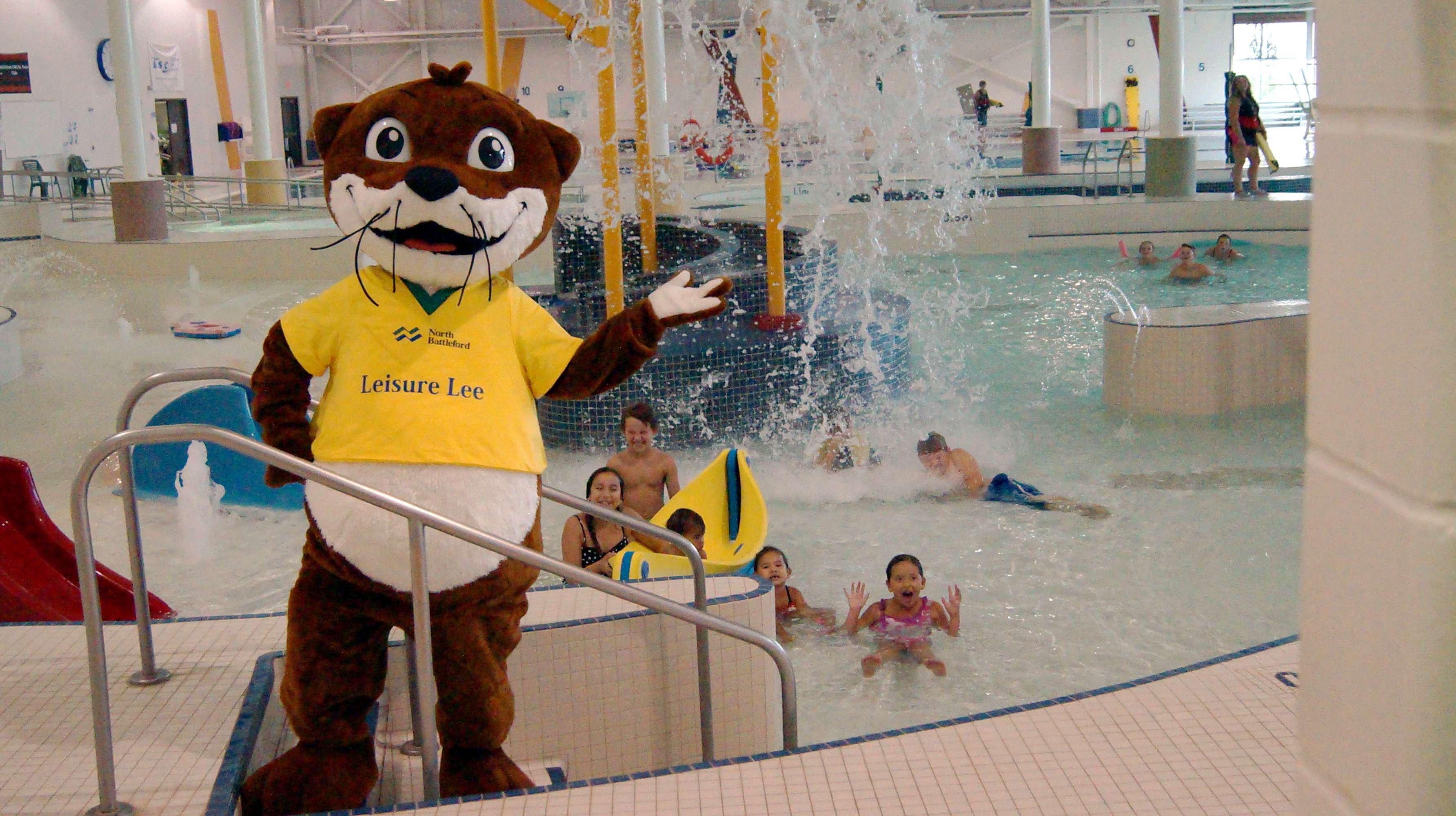 Lesire Lee mascot at the pool with kids getting splashed by water from a large bucket in the background.