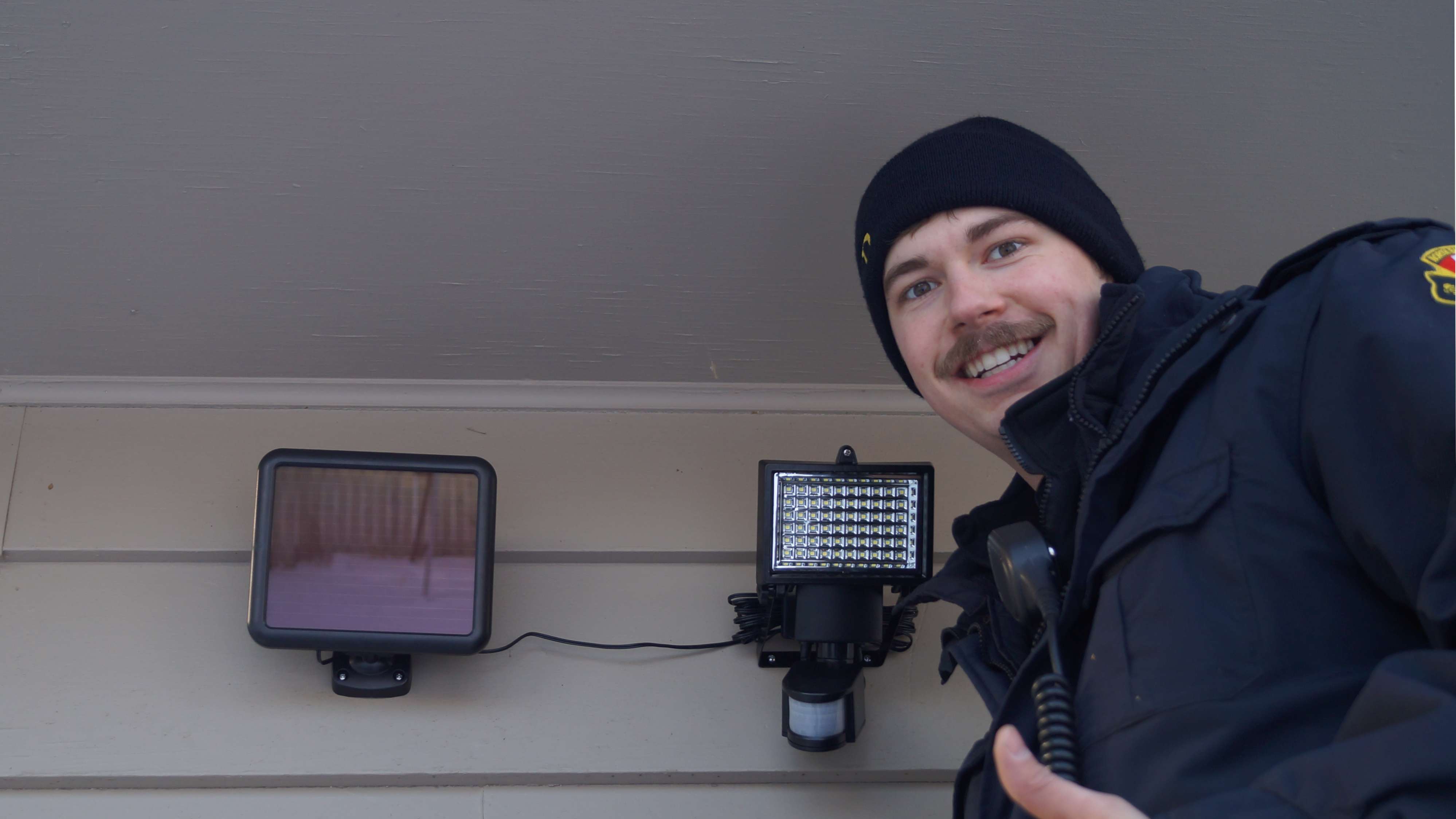 A firefighter shows off a sucessfully installed motion light.