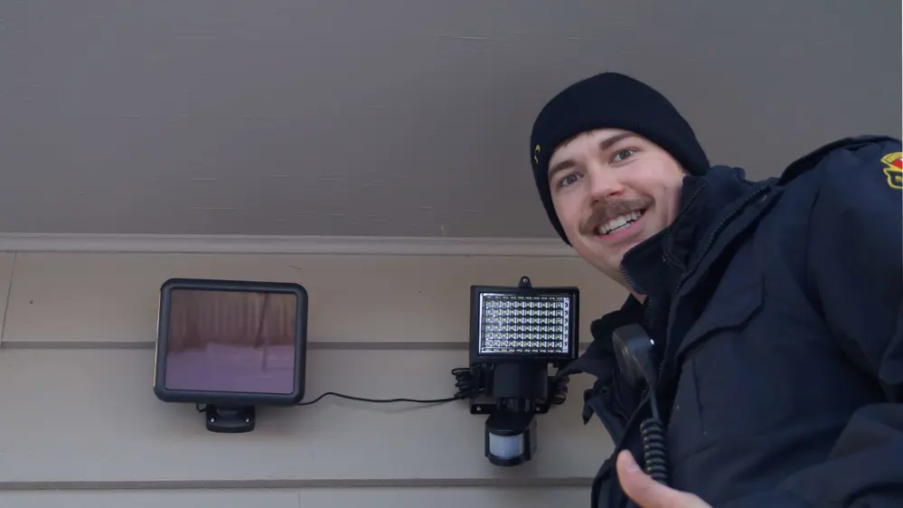 A firefighter shows off a sucessfully installed motion light.